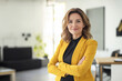 © sinseeho - Smart looking businesswoman wearing yellow jacket in a modern office.