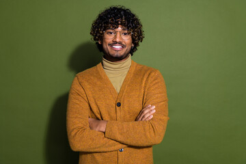 Wall Mural - Photo portrait of pretty young male crossed hands confident wear trendy brown outfit isolated on khaki color background