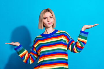 Poster - Portrait of pretty young girl arms hold empty space wear striped pullover isolated on blue color background