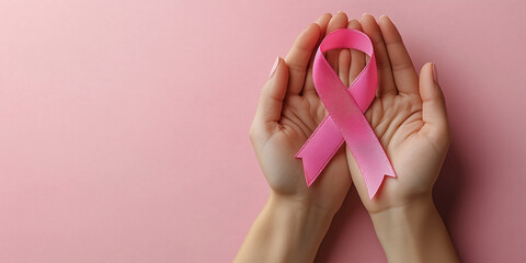 Adult hands holding pink ribbon with Copy space for World cancer day