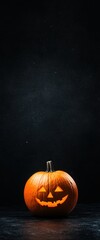 Wall Mural - A pumpkin with a smiley face on it is sitting on a black surface