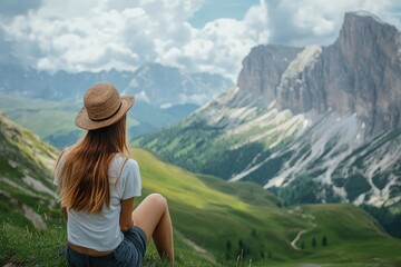 Poster - a woman sitting on top of a lush green hillside