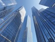 © adri - A low angle view of modern skyscrapers reaching towards a bright blue sky.