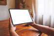 © Farknot Architect - Mockup image of a woman holding digital tablet with blank desktop screen at home