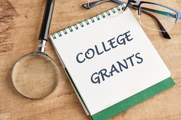 Business and COLLEGE GRANTS concept. Copy space. Grant symbol COLLEGE GRANTS in a notebook on a papyrus background, top view