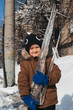 © alexkoral - A Caucasian boy holds an icicle in his hands outside in winter. vertical