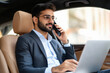 © Niks Ads - young indian businessman working on laptop in car