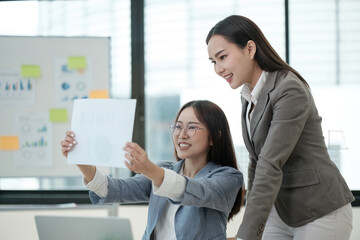 Wall Mural - Two women are looking at a piece of paper