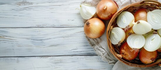 Canvas Print - Wicker basket containing whole and sliced onions on a light grey wooden table top view Copyspace available