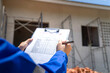© Nattawit - An architect is checking on house building quality checklist form to inspecting the progress with building house as blurred background. Construction industrial working scene, close-up.