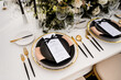 © Cavan Images - Wedding reception table with black and white place setting