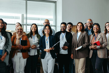 Wall Mural - diverse team of business professionals at a conference with smiling employees and businesswomen