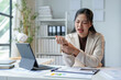 © Phimwilai - Asian woman stressed or tired, arm pain, waist pain, body aches at the office while working on laptop Asian business woman feeling sick at work, office syndrome concept.
