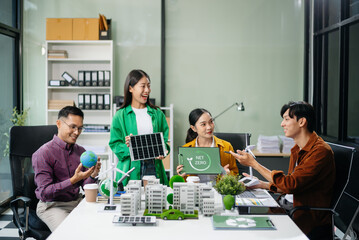 Asian professionals collaborate on sustainable energy solutions with wind turbines, solar panels, and eco friendly models