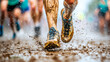 © Kunut - Close up of runners mud splattered legs and shoes, showcasing intensity of race. splashes of mud and water create dynamic and energetic scene.