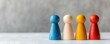 © Kasitthanin - Colorful wooden game pieces lined up on a table, representing teamwork, strategy, and board games in a minimalist setting.