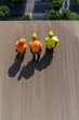 © Atlas - Three workers in bright safety gear preparing to work on a rooftop in an urban environment