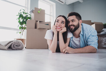 Canvas Print - Portrait of two young people lying floor think relocating moving box package new apartment indoors