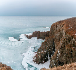 Poster - Mystical winter storm on the shore of a frozen sea with rocky shores. Winter frozen sea and snowstorm. Winter sea fairy tale.