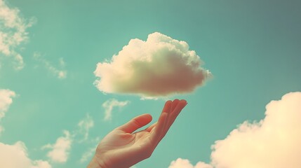 Wall Mural - Human hand gently lifting a fluffy white cloud in a turquoise sky