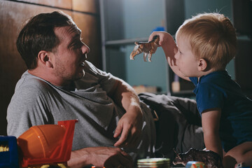 Little boy with his dad playing with toys at home. Happy father and son spending time together