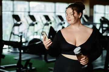 Wall Mural - A young woman embraces body positivity as she works out in active wear, checking her phone.