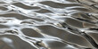 © AI_images - A silver textured surface with a smooth, rippled pattern, mimicking gentle waves in a calm body of water, cast in metal.
