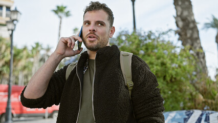 Sticker - Handsome hispanic man with beard talking on phone outdoors in an urban street setting.