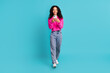 © deagreez - Full body photo of attractive teen girl hold device walking dressed stylish pink clothes isolated on aquamarine color background