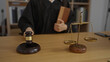 © Krakenimages.com - Judge holding book in courtroom with gavel and scales of justice on the desk