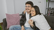 © Krakenimages.com - A happy couple cuddles on a couch, exemplifying love and companionship in a cozy living room.