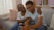 © Krakenimages.com - Mother and son sharing a moment of love and laughter in their living room at home, the woman lovingly smiles at her son while they look at a smartphone together