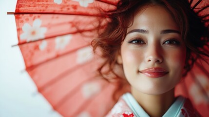 Close-up of a smiling woman in traditional attire holding an ornate parasol, highlighting the harmony of cultural heritage and joyful expression amidst a vibrant background.