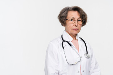 Portrait of serious senior woman doctor in uniform stand isolated on white studio background copy space. Mature female medical nurse or practitioner with stethoscope look at camera. Healthcare concept