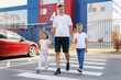 © Studio Peace - A father with his son and daughter cross the road at a pedestrian crossing.