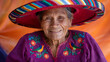© Erika - Elderly Hispanic Woman in Colorful Traditional Hat and Embroidered Blouse Smiling Warmly