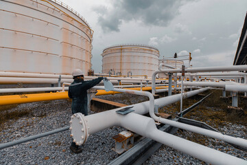 Wall Mural - Male worker inspection at steel long pipes and pipe elbow in station oil factory during refinery valve of visual check record pipeline oil and gas