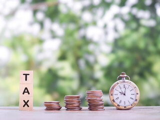 Wall Mural - Vintage watch and Wooden blocks with the word TAX on stack of coins. The concept about saving money and manage time to paying tax