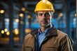 © Introvertia - Serious construction worker portrait industrial setting with hard hat