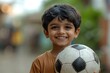 © Dilshad - Cheerful Indian Kid Showing Off Their Football with a Big Smile