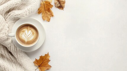 Cozy autumn morning: a cup of latte with leaf art, surrounded by a warm knit sweater and fallen maple leaves on a light background. Perfect for seasonal blogs.