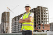 © Studio Peace - Architect working on a construction site in a protective helmet and vest.