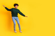 © deagreez - Full body portrait of nice young man balancing empty space wear sweater isolated on yellow color background