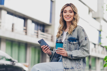 Canvas Print - Portrait of pretty young girl enjoy coffee use phone wear denim jacket walk street outdoors