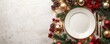 © MK studio - Christmas table setting. A beautifully arranged holiday table setup includes a plate and cutlery surrounded by festive decorations of pine branches, ornaments, and pine cones.