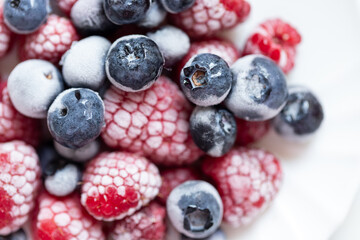 Frozen organic berries on the white plate close up