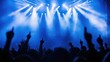 © amankris99 - Crowd at a concert with raised hands and vibrant blue stage lights creating an energetic atmosphere.