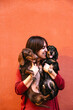 © ADDICTIVE STOCK - Young woman holding two happy Teckel dogs