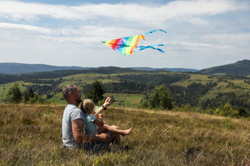 Wall Mural - Father with daughter flying kite at field