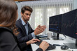 © InfiniteFlow - Two business traders analyzing dynamic stock market in currency rate investment program website online on two computer screens, woman checking to compare real time graph at modern office. Postulate.